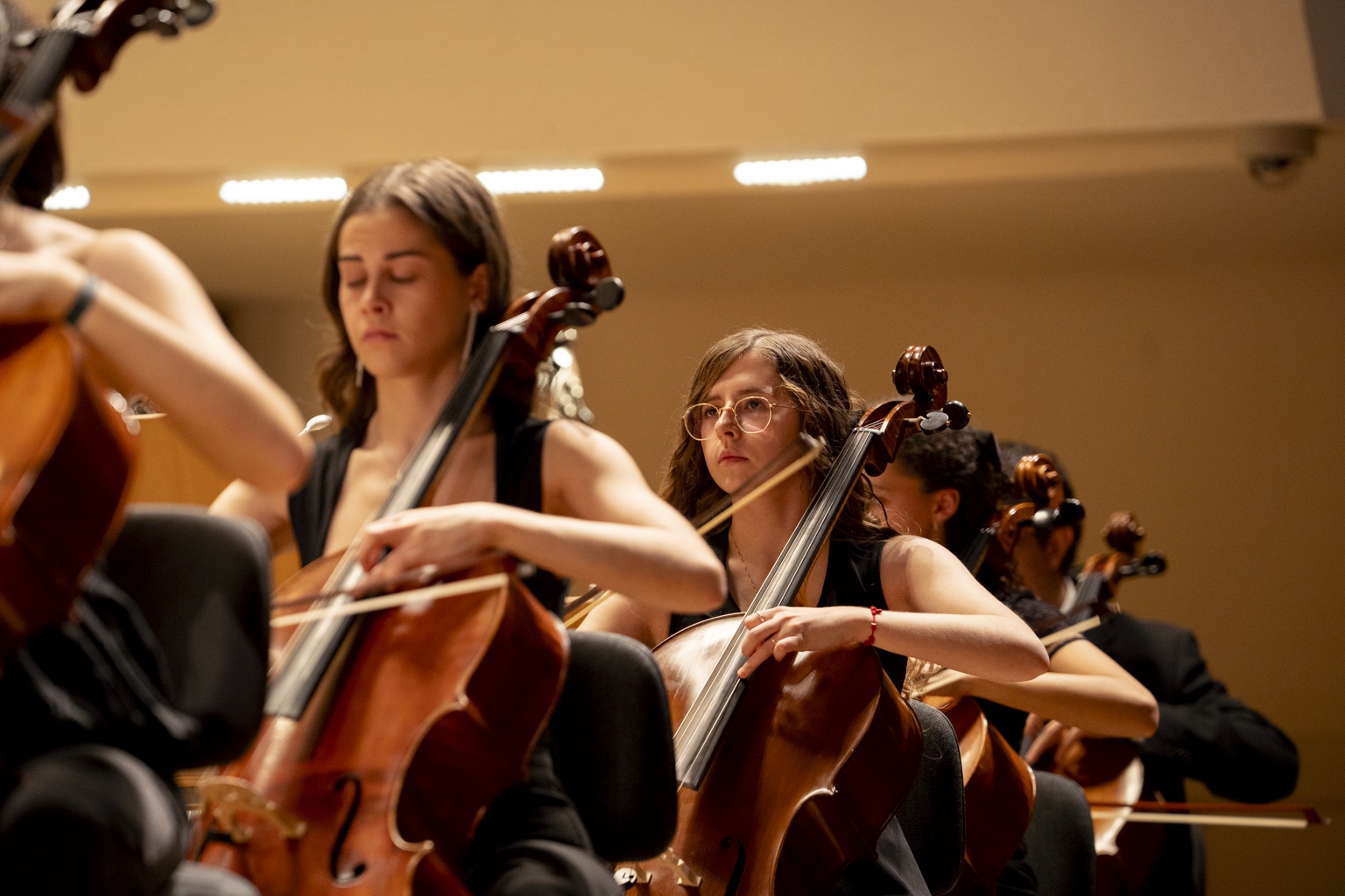Joven violonchelista interpretando junto a su sección