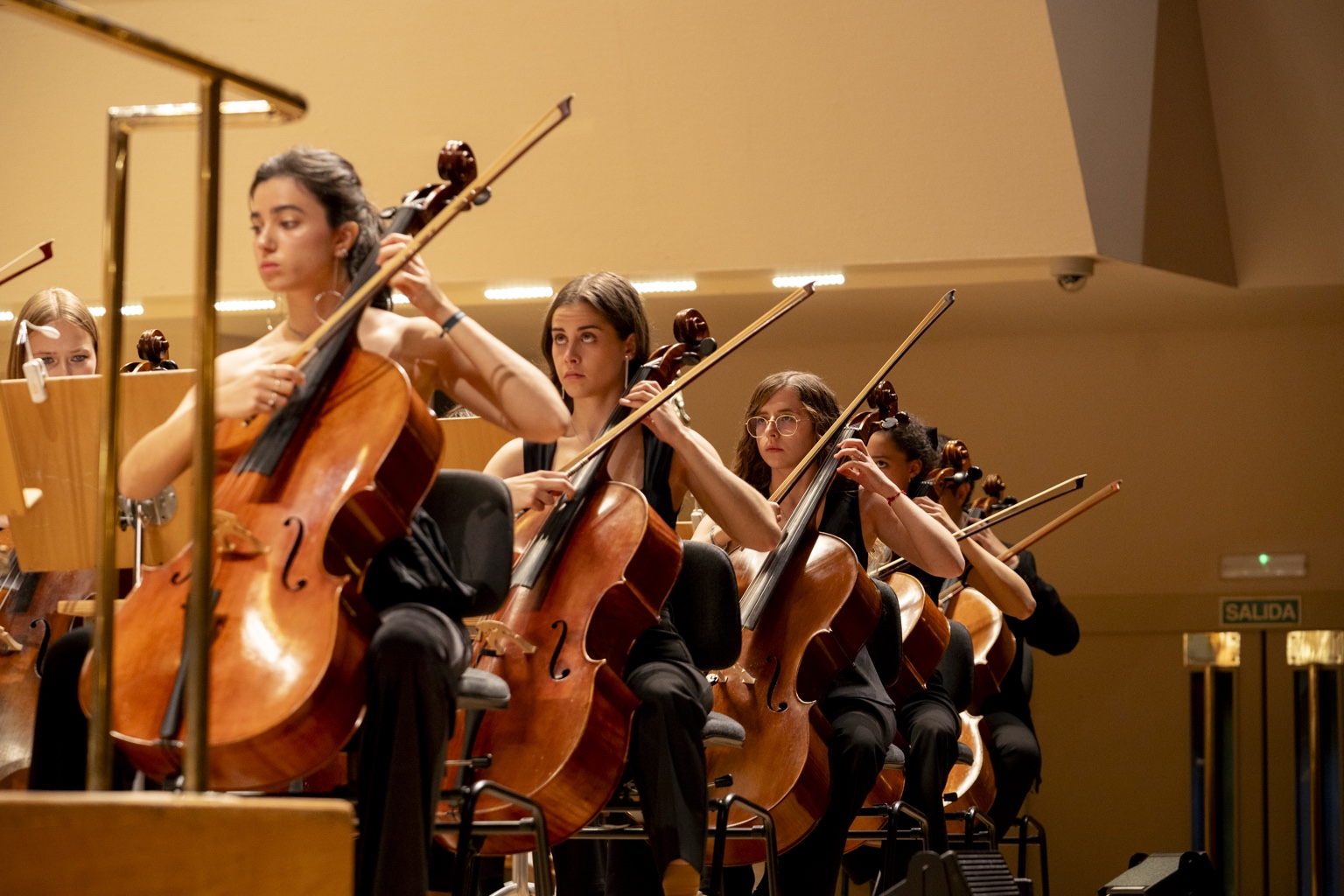 Jóvenes violonchelistas tocando juntas sobre el escenario